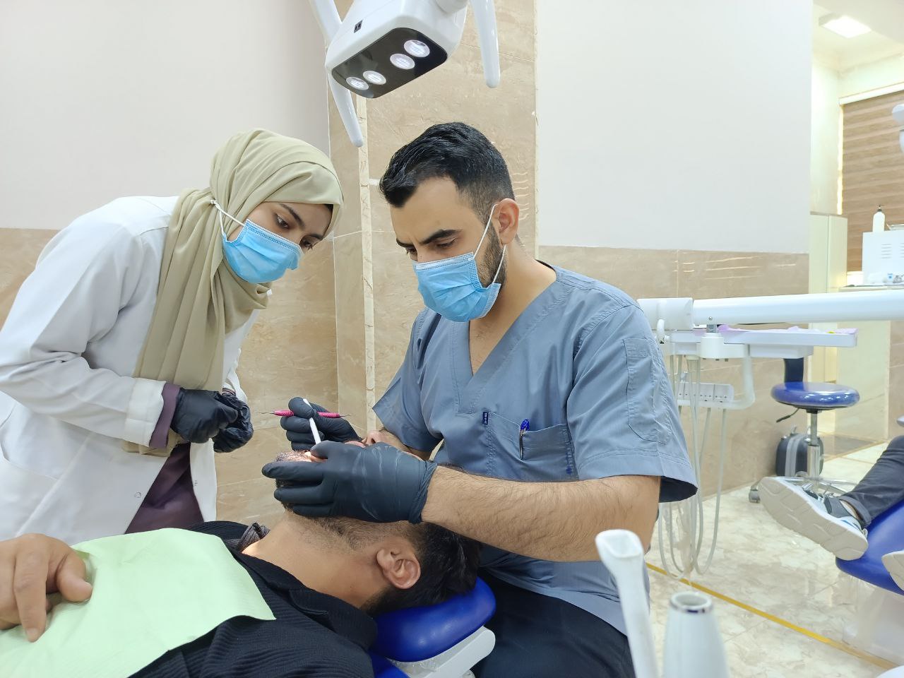 أجراء تنظيف الأسنان العميق لمريض في عيادة أمراض اللثة .