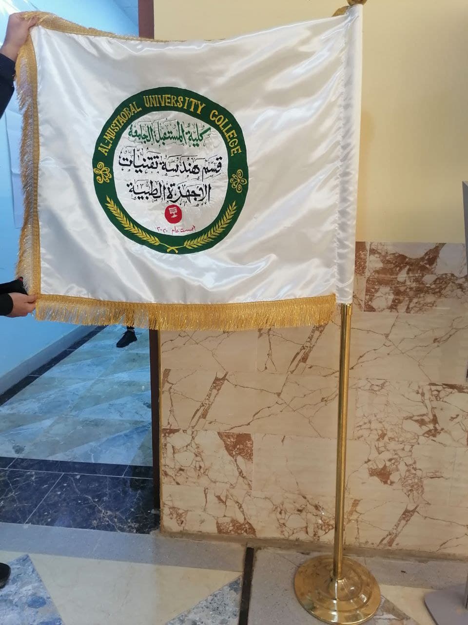 خياطة وتطريز علم لقسم هندسة تقنيات الأجهزة الطبية في كلية المستقبل الجامعة